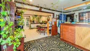 A restaurant with a wooden counter, a patterned carpet, and hanging plants. - Purple Sage By OYO Snyder TX (Snyder)