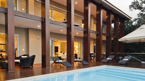 A modern hotel with a pool area, multiple balconies, and outdoor seating. - Luxury Seaside Homes (Pennington)