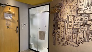A hotel room with a wooden door, a frosted glass door, and a wall with a detailed mural. - Cho Hotel (Taipei)