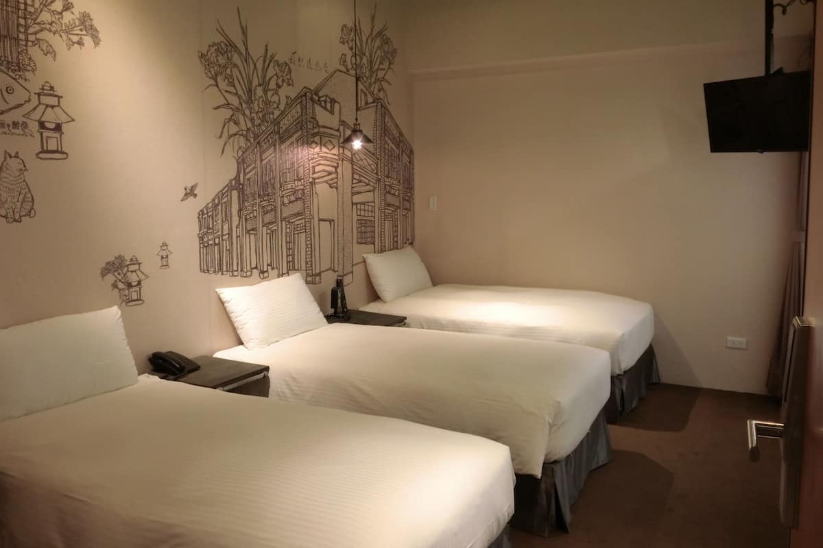 Une chambre d’hôtel avec deux lits, une fresque murale, un téléviseur et un téléphone sur la table de chevet.