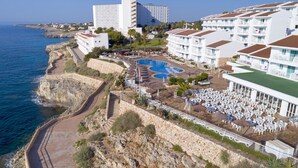 Ein Küstenhotel mit Pool, Außenbereich und Meerblick.