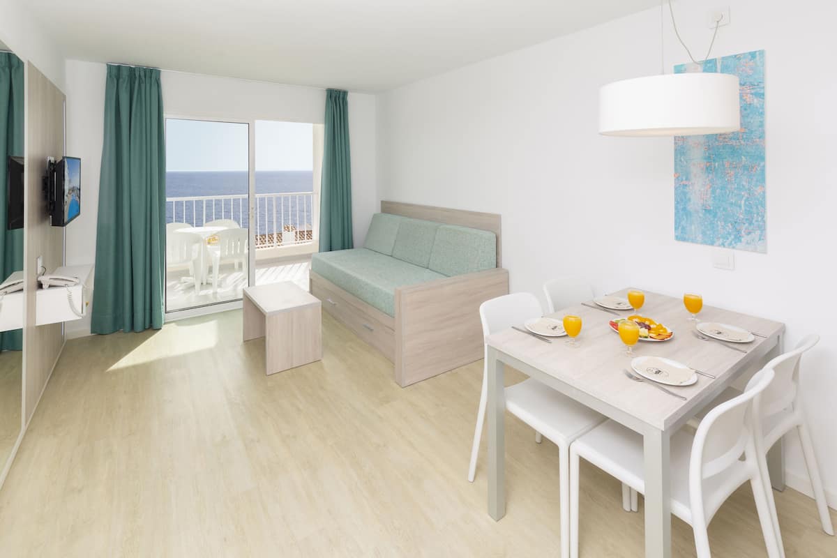 Une chambre d’hôtel moderne avec un balcon, un coin repas et un lit.