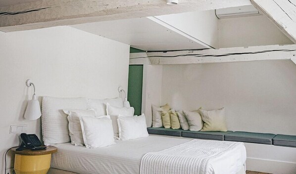 A bedroom with a bed, bedside lamps, a telephone, and a green accent wall. - Hotel des Galeries (Brussels)