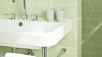 A bathroom with a white sink, chrome faucet, and towel rack.