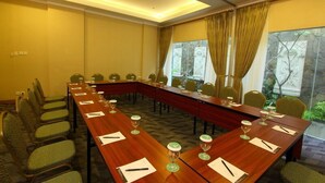 A conference room with a long table, chairs, and glassware.