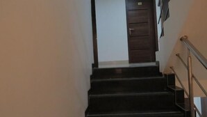A staircase with a handrail leading to a door. - Krishna Avatar Stay Inn (Navi Mumbai)