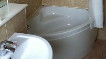 Un baño con bañera, ducha y lavamanos.