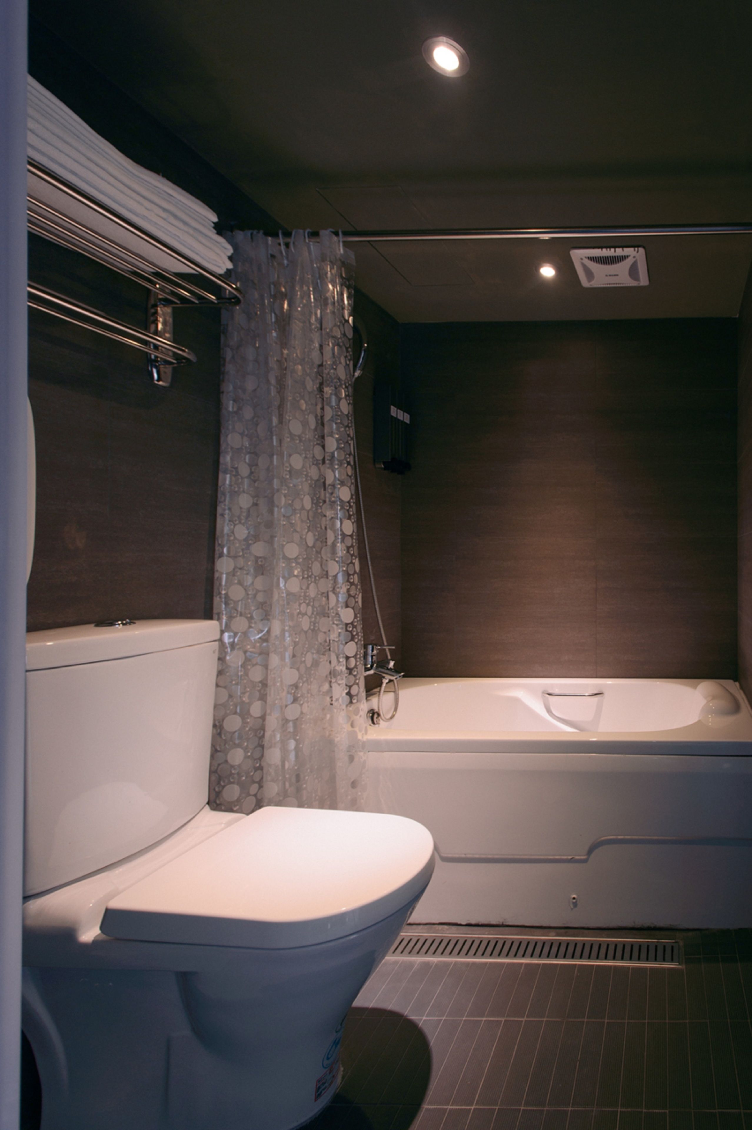 A bathroom with a toilet, a bathtub, and a shower curtain.