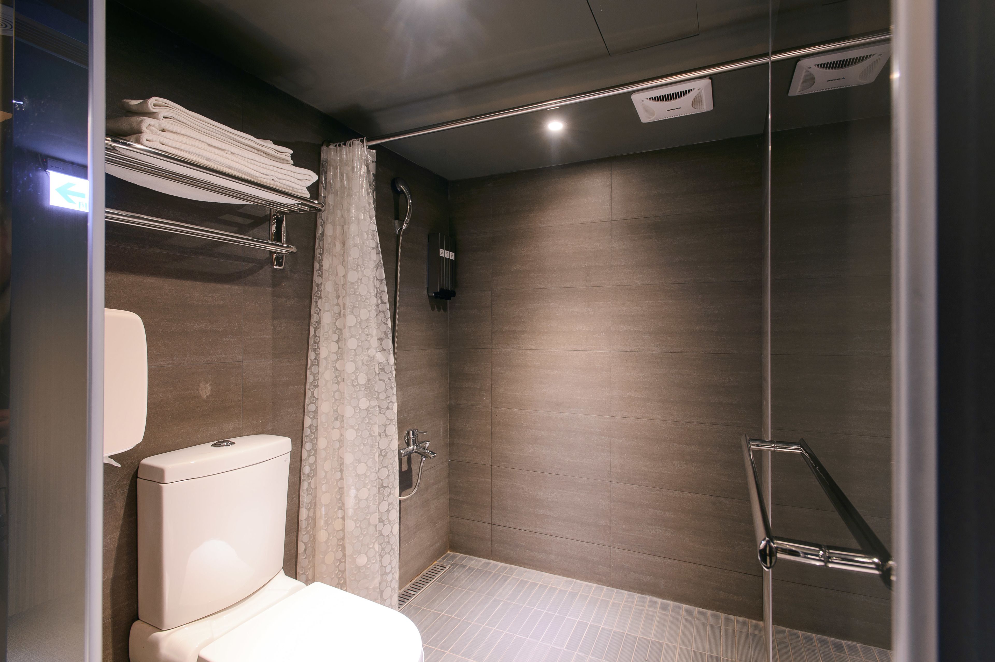 Een moderne badkamer met toilet, douche en glazen deur.