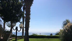 Une pelouse bien entretenue, avec un lampadaire et une vue sur la mer.