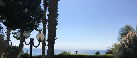Un jardí ben cuidat amb un fanal i vista al mar.