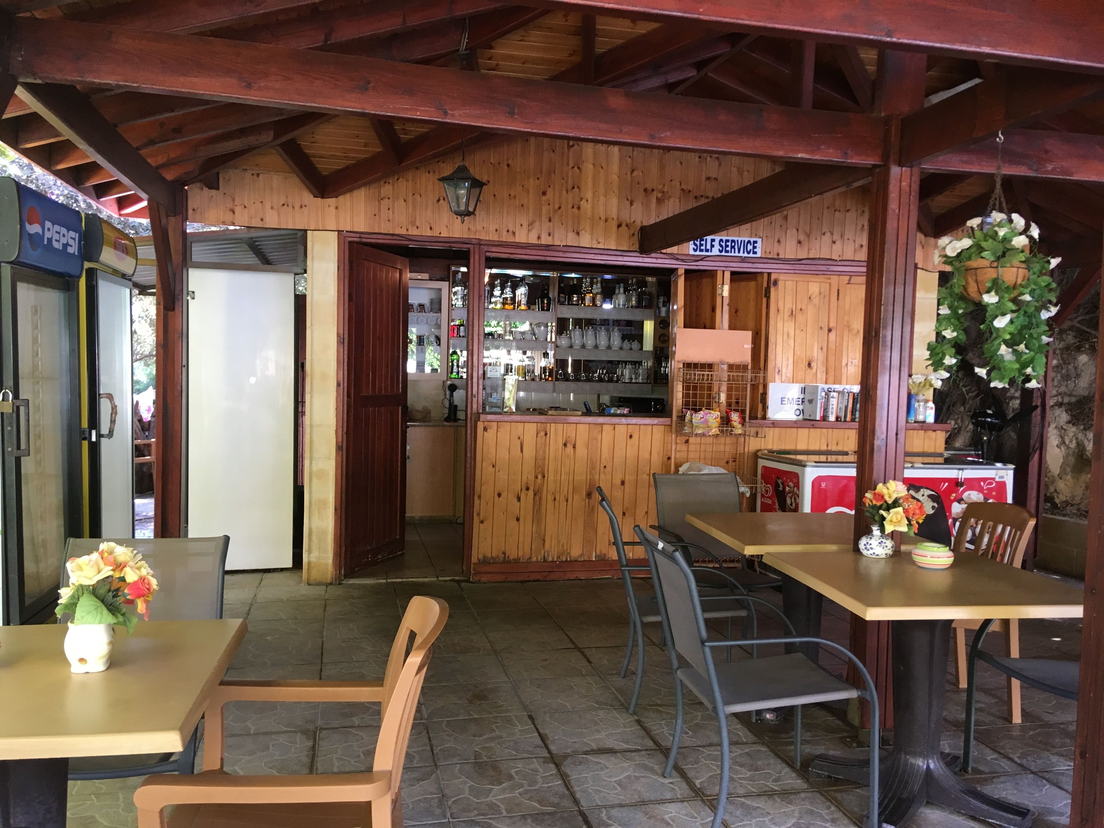 Un interior rústico de madera con barra, mesas y sillas.