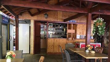 Un interior rústico de madera con barra, mesas y sillas.