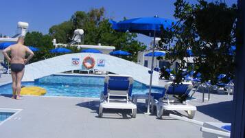Relax by the pool with lounge chairs and umbrellas nearby.