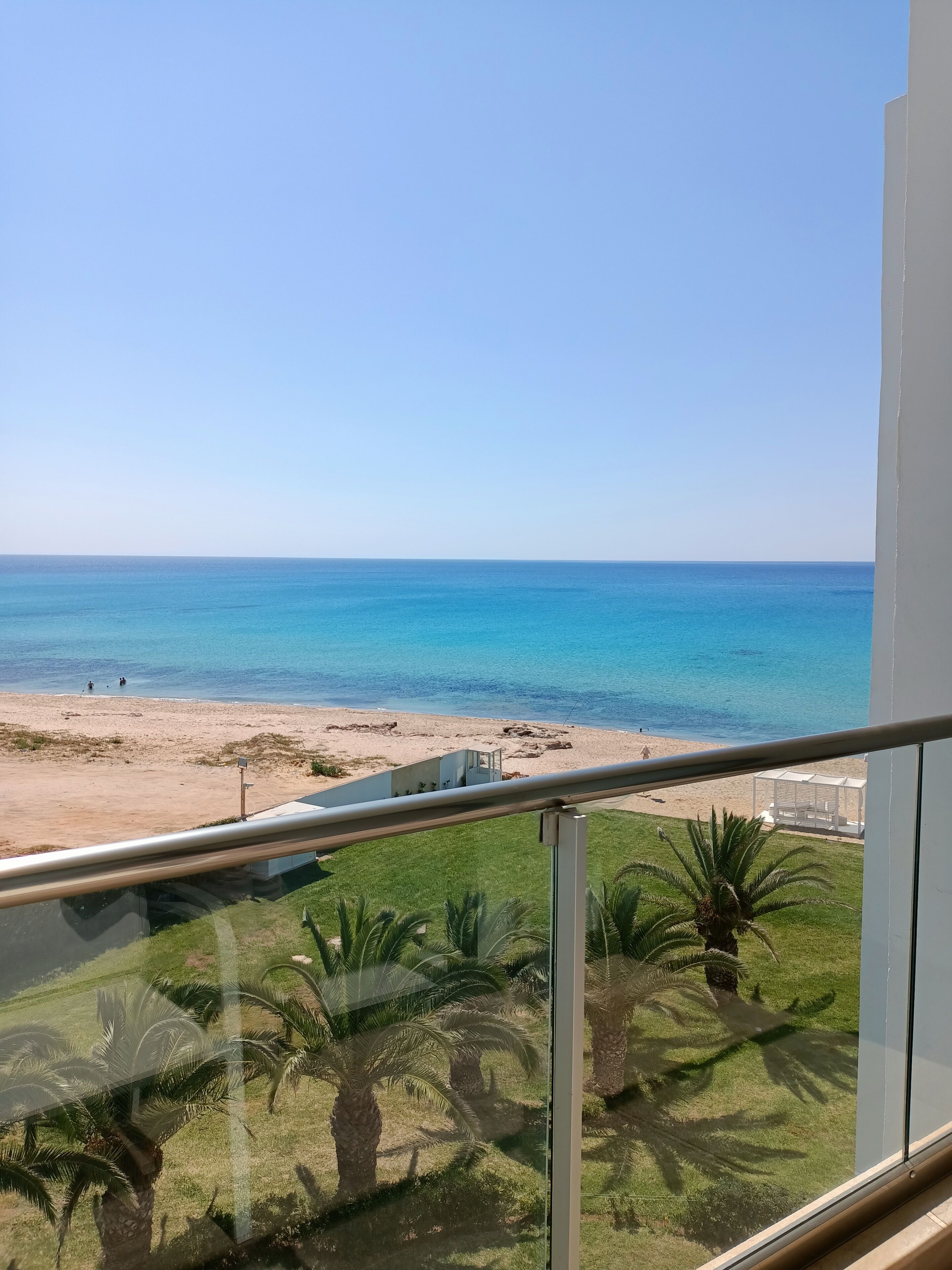Ein Balkon mit Blick auf Strand und Meer.
