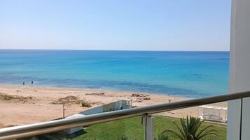 Ein Balkon mit Blick auf Strand und Meer.