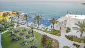 A resort with a pool area, lounge chairs, and palm trees. - La Badira - Adults Only (Hammamet)