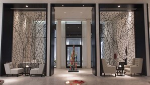 A lobby with two seating areas, a decorative centerpiece, and a stone basin with flowers. - La Badira - Adults Only (Hammamet)