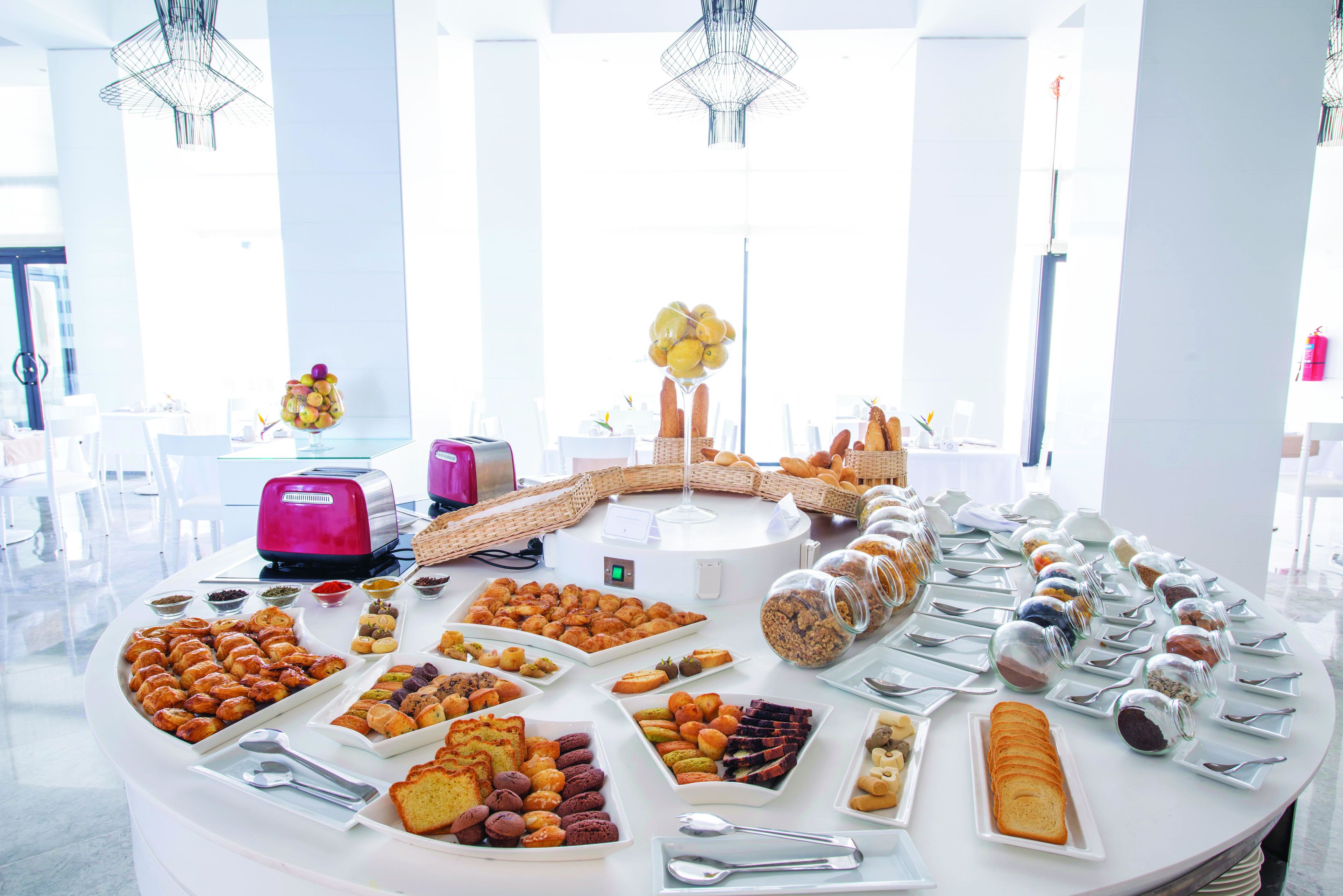 A buffet table with various food items and a toaster.