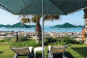 Praia particular, espreguiçadeiras, guarda-sóis, toalhas de praia 