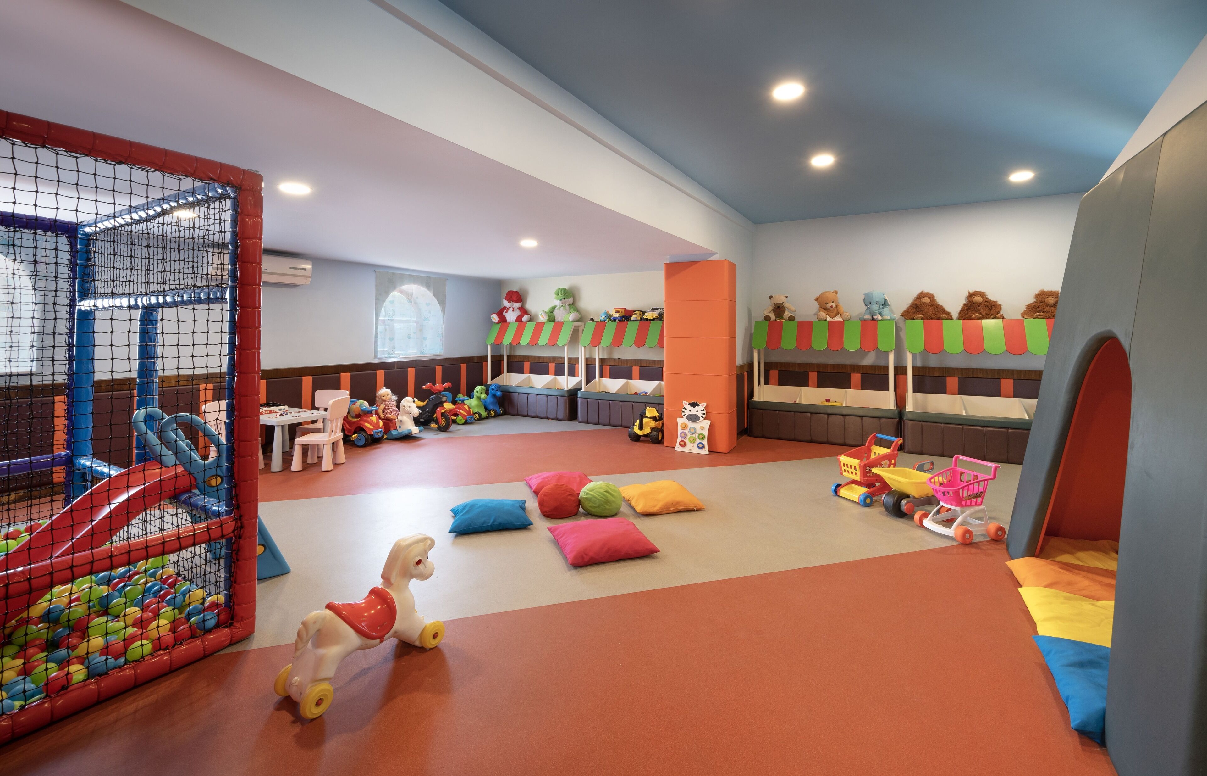 A children's play area with a ball pit, play structures, and colorful toys.