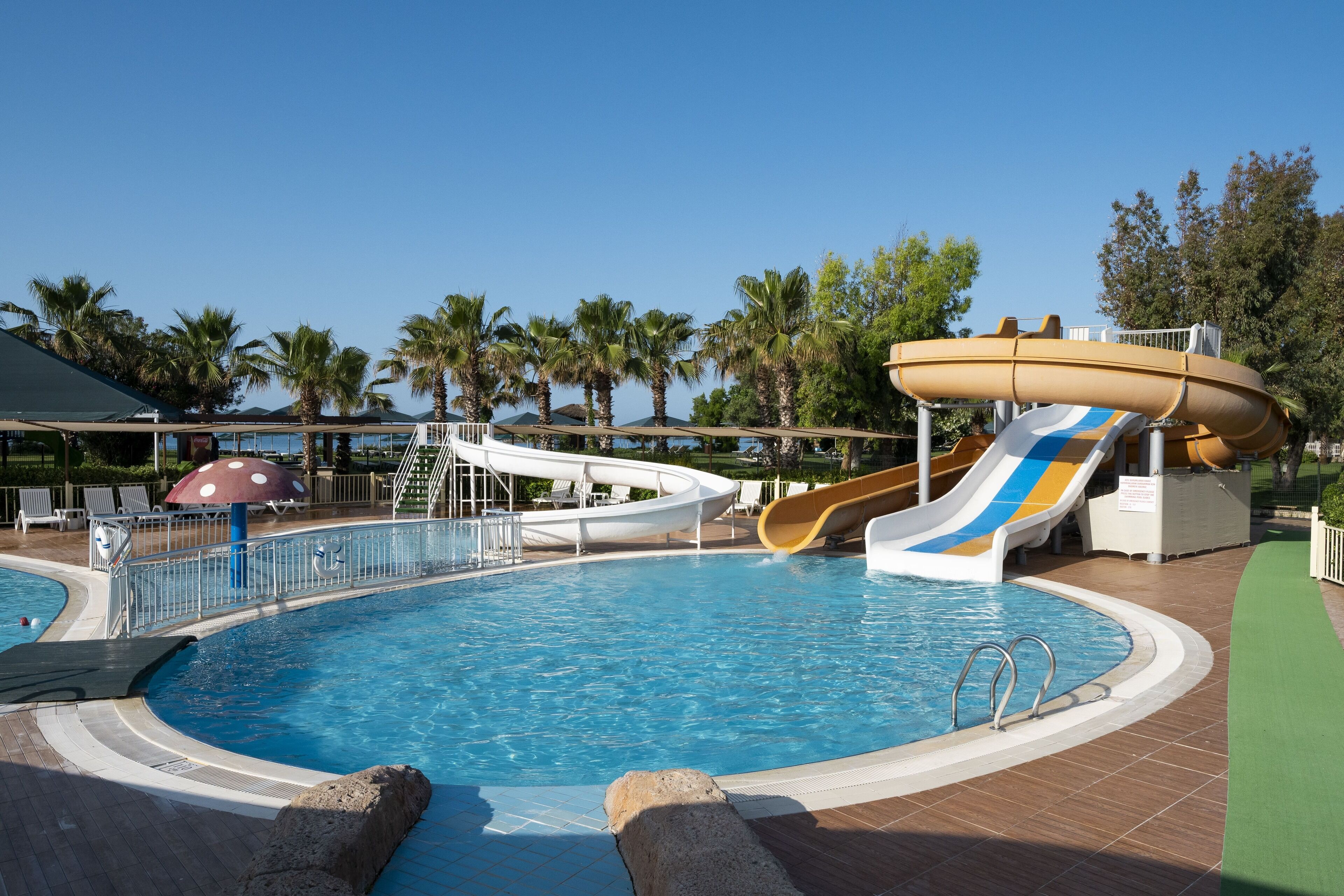 A swimming pool with slides and a lifeguard stand.