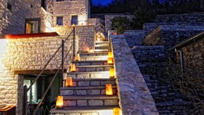 Un escalier en pierre, dont les marches sont éclairées, mène à un bâtiment.