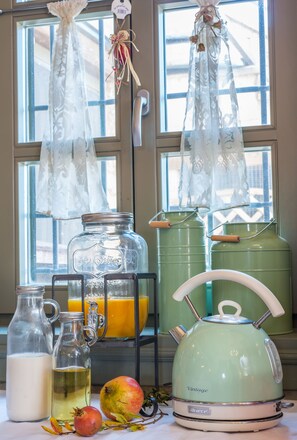 A kitchen counter with a vintage kettle, glass jars, and a pomegranate. - Pirrion Wellness Hotel (Zagori)