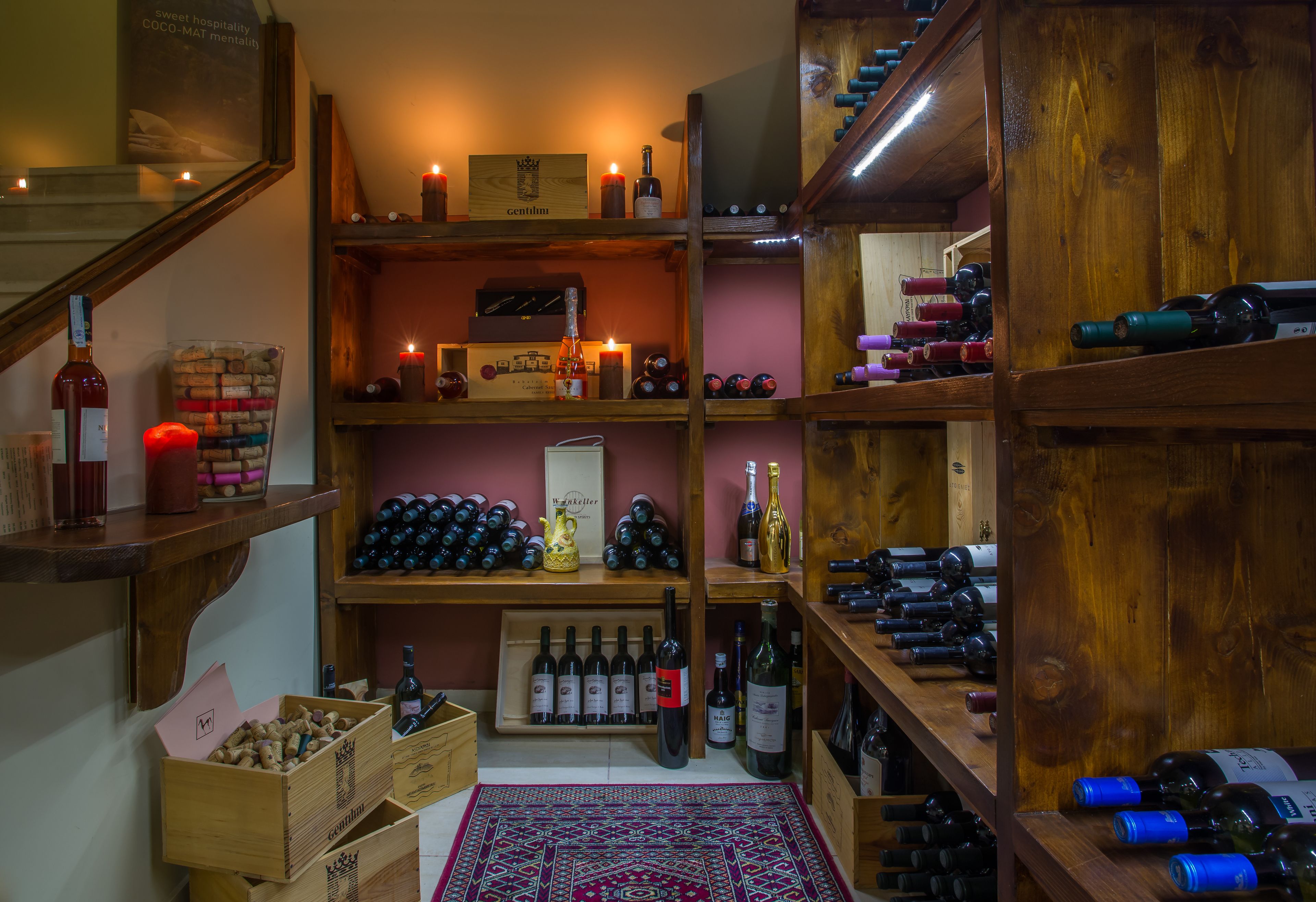 Una bodega con estantes y botelleros de madera, que contiene varias botellas de vino.