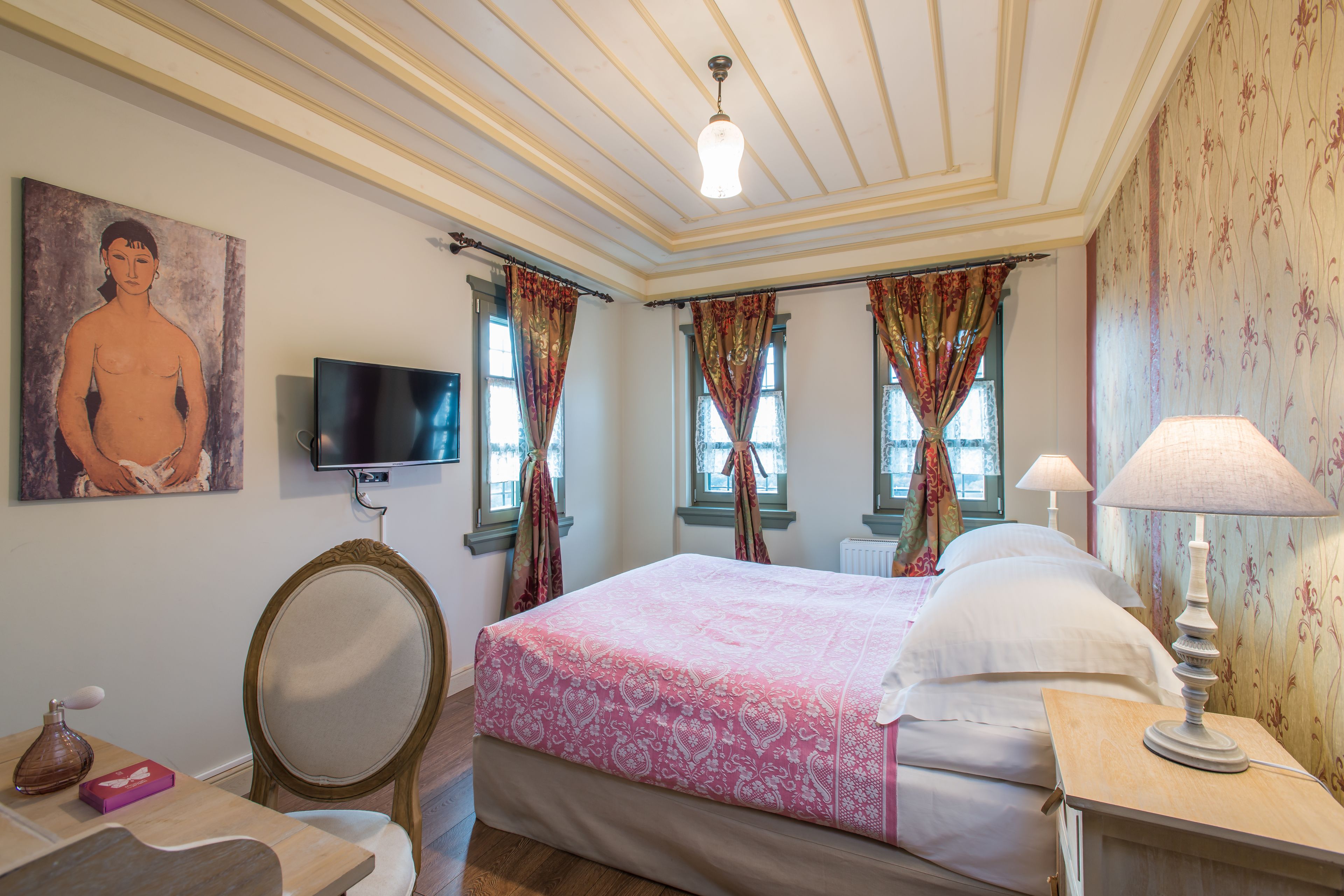 A bedroom with a bed, a TV, a mirror, and a lamp.