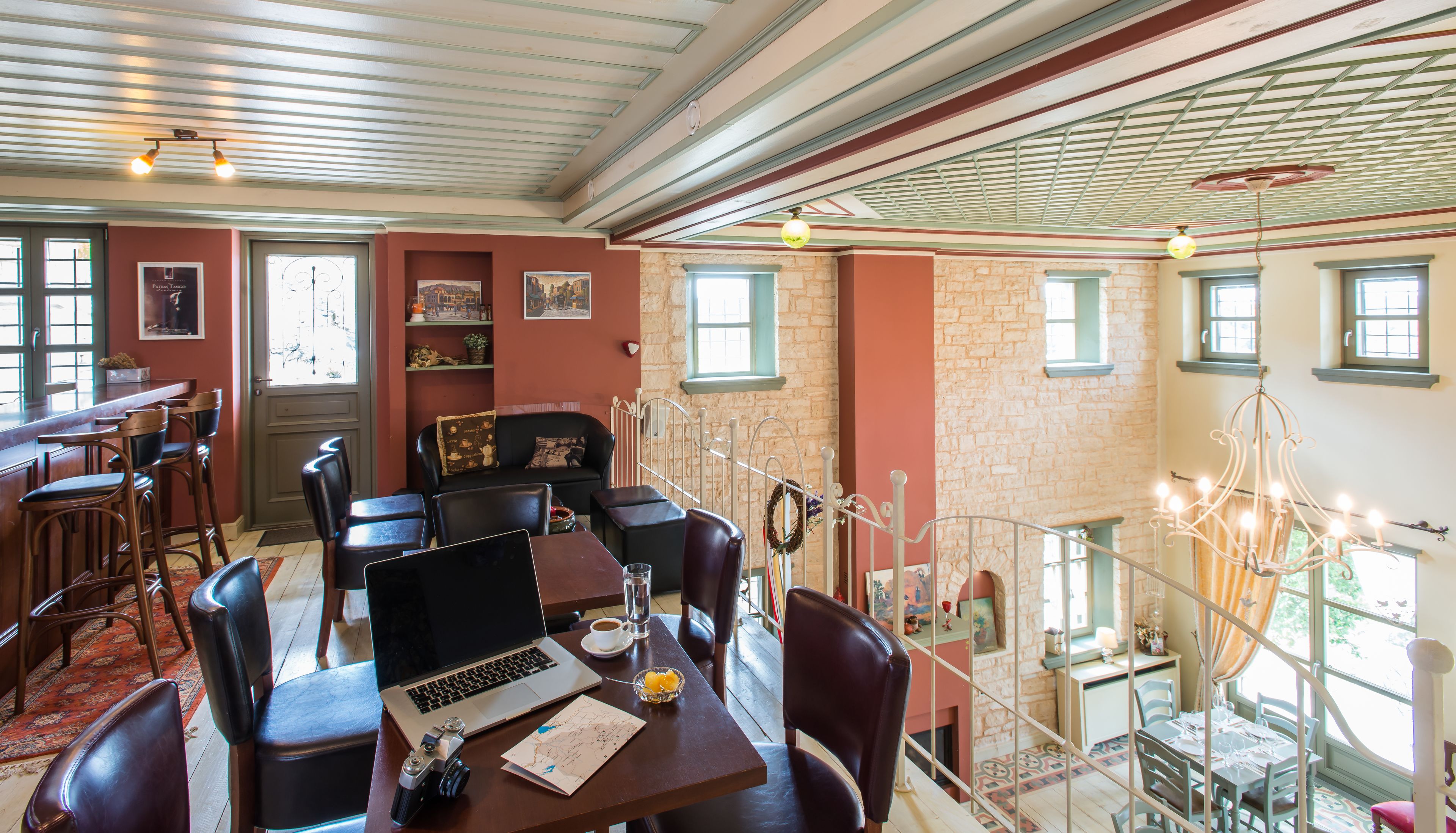 A dining area with a laptop, camera, and map on a table, surrounded by chairs.