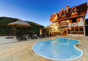 Una piscina al aire libre, sillones reclinables de piscina