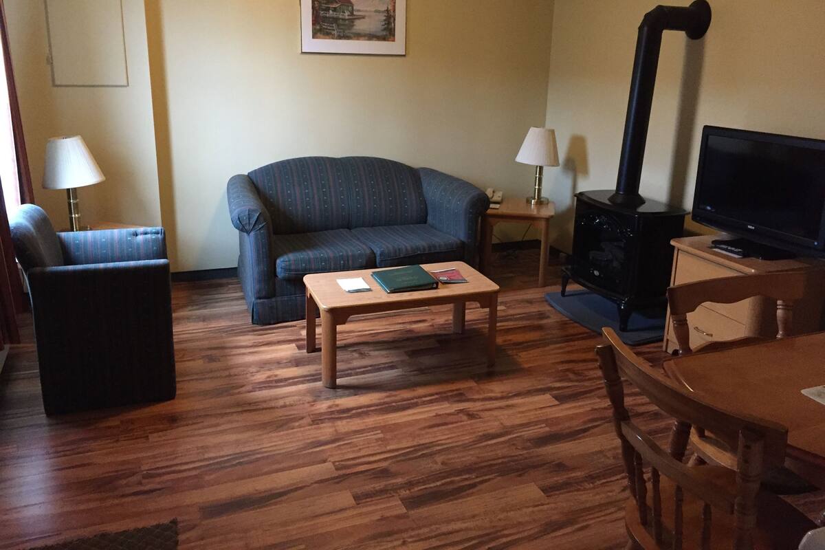 A living room with a sofa, a coffee table, a television, and a fireplace.