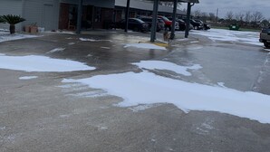 Une station-service dotée d’un espace de stationnement couvert, de la neige au sol et d’un ciel nuageux.