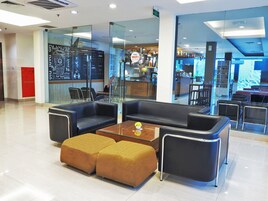 Uma área de estar moderna com assentos de couro, uma mesa de centro e uma divisória de vidro.