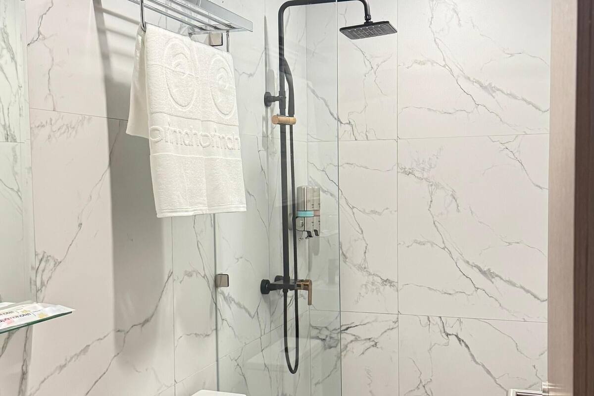 deluxe room | bathroom | shower, hair dryer, slippers, towels