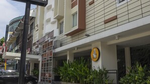 A hotel with a modern design, featuring a prominent 'd'primahotel' sign, a logo with a chef, and a well-maintained outdoor area with plants and a parking lot. - d'primahotel ITC Mangga Dua (Jakarta)