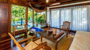A wooden-floored room with a bed, a table, chairs, a hammock, and a view of greenery outside. - Sombra e Água Fresca Resort (Tibau do Sul)