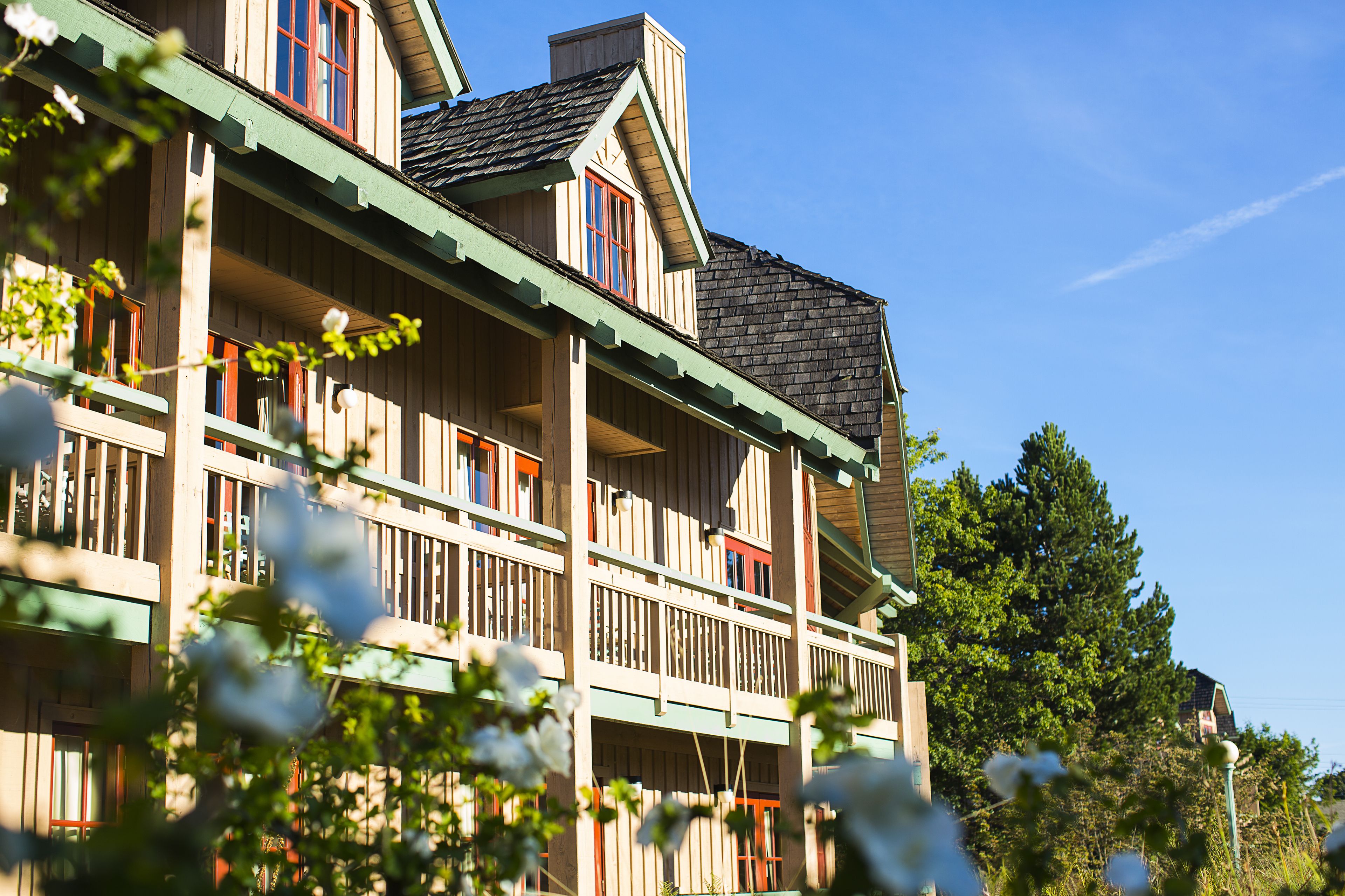 A multi-story building with balconies and a steep roof.
