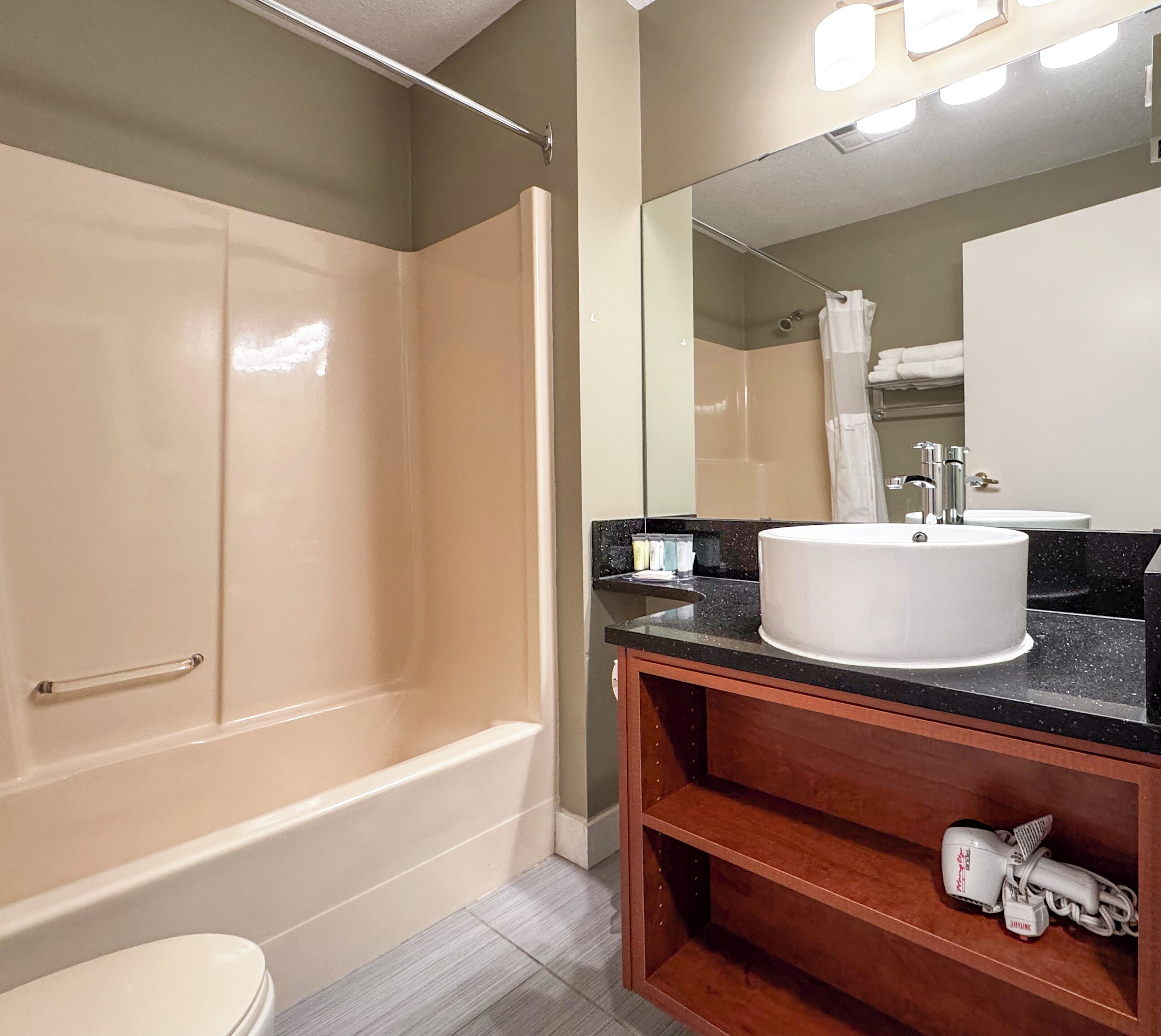 Une salle de bain avec une baignoire, un lavabo et un miroir.