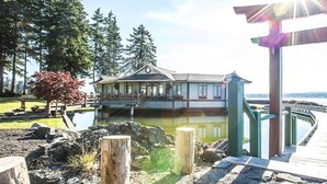A waterfront property with a covered porch, a wooden deck, and a view of the water. - April Point Resort  (Quadra Island)