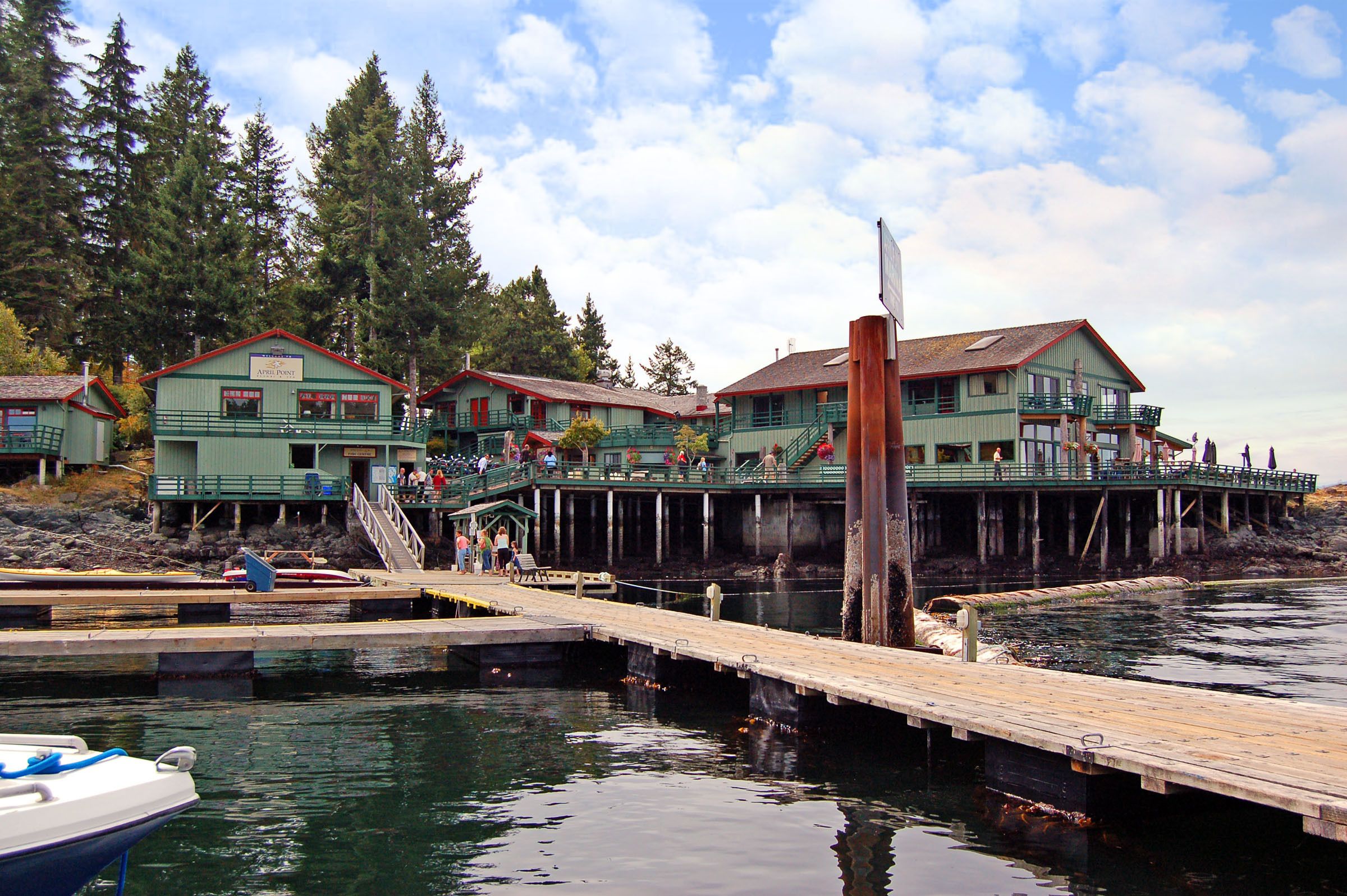 A waterfront property with multiple buildings, a dock, and a pier.