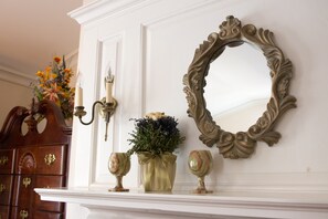 A fireplace mantel with a mirror, candle holder, and decorative items.