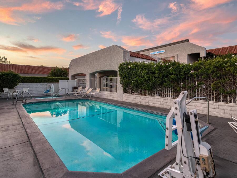 A swimming pool with lounge chairs and a lifeguard stand.