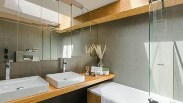 Un baño moderno con dos lavamanos, cabina de ducha de vidrio y una bañera grande.