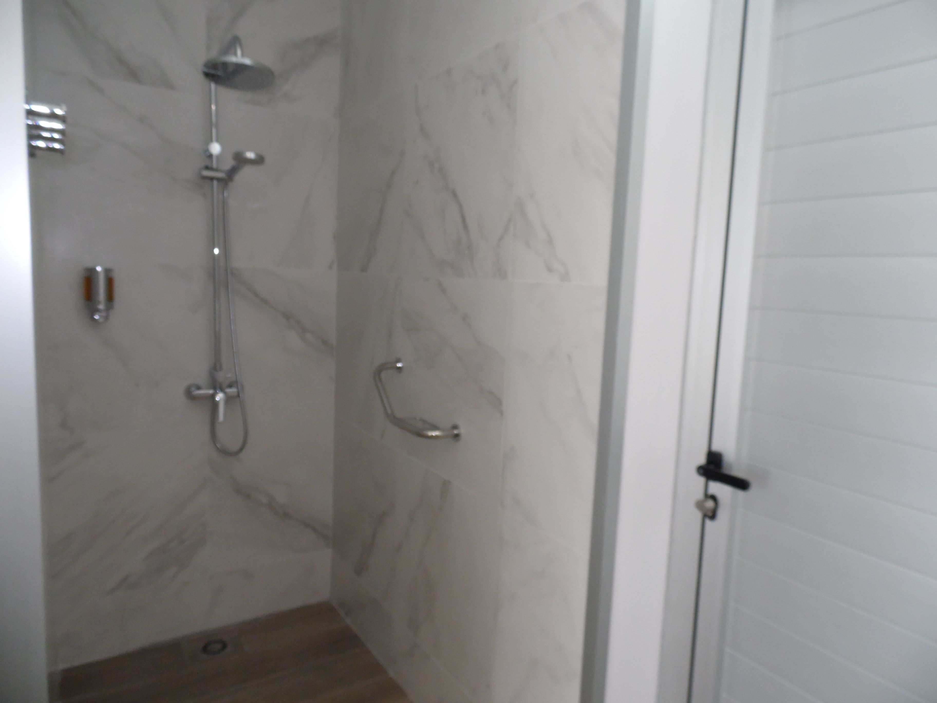 A bathroom with a shower, a toilet, and a sink.