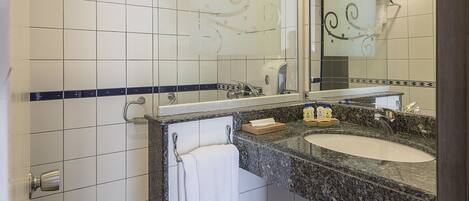 Un baño moderno con un espejo grande, dos lavamanos y un perchero para toallas.