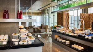 A modern hotel breakfast area with a buffet setup, seating, and a view of the city. - The Westin Chongqing Liberation Square (Chongqing)