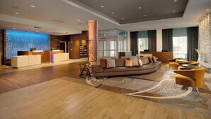 A spacious lobby with a reception desk, a sofa, and a coffee table.