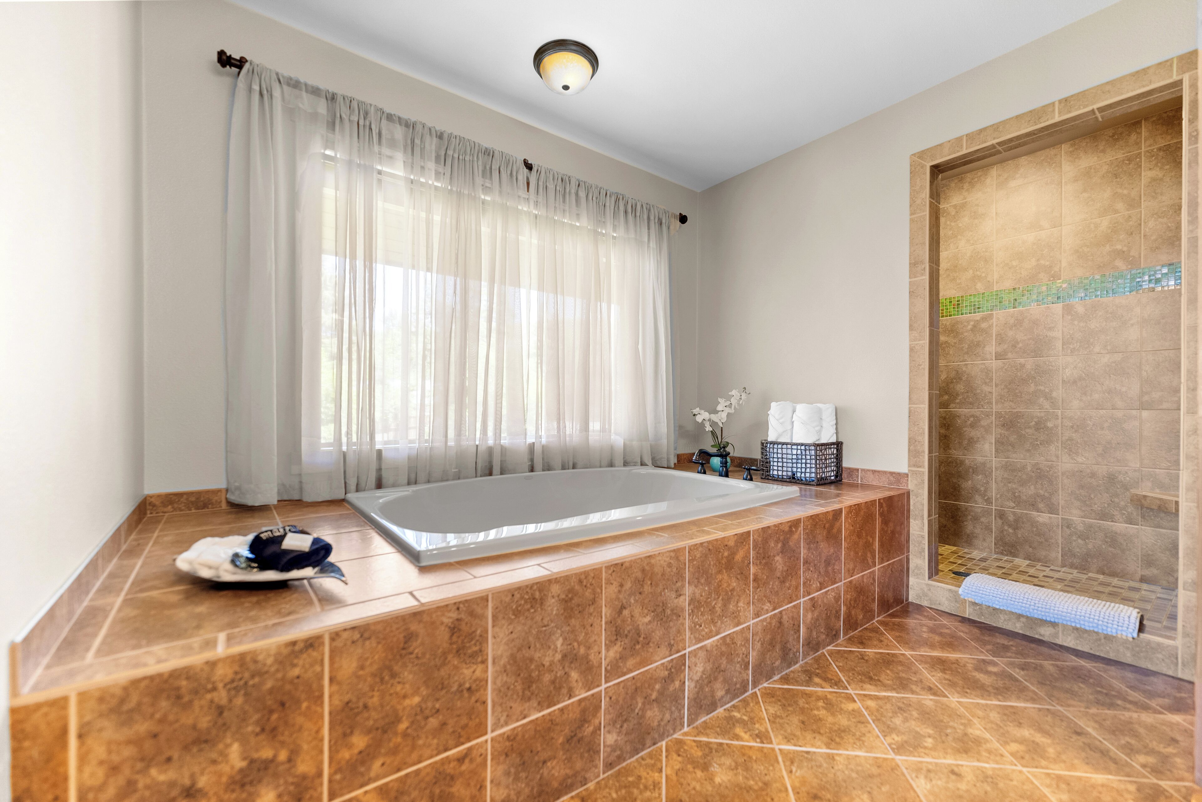 A bathroom with a large bathtub, a shower area, and a toilet.